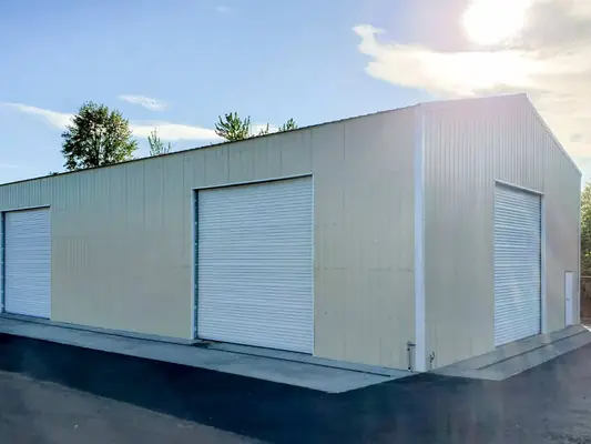 Large cream metal building with roll-up doors