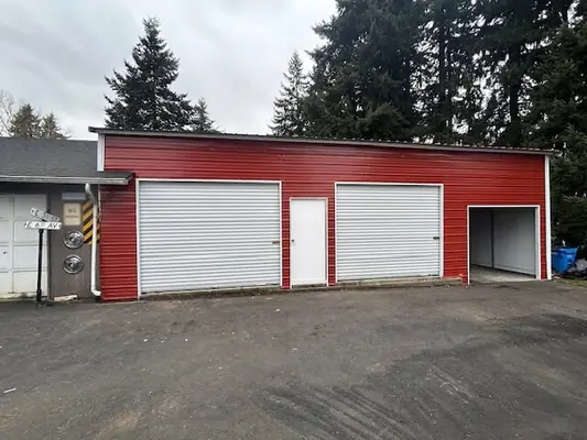 Red metal building with three bay doors