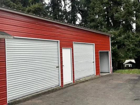 Red metal building with bay doors on the side