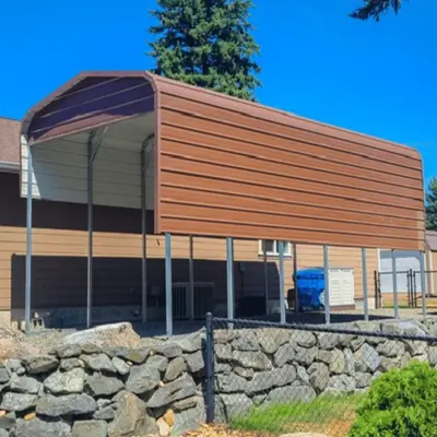 Brown metal carport above a rock retaining wall