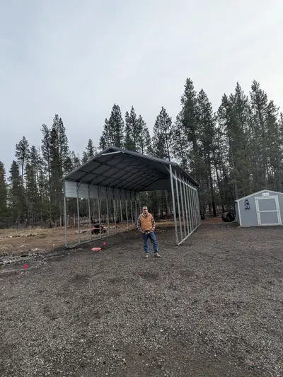 Finished 20x40x12 steel carport with the customer on site